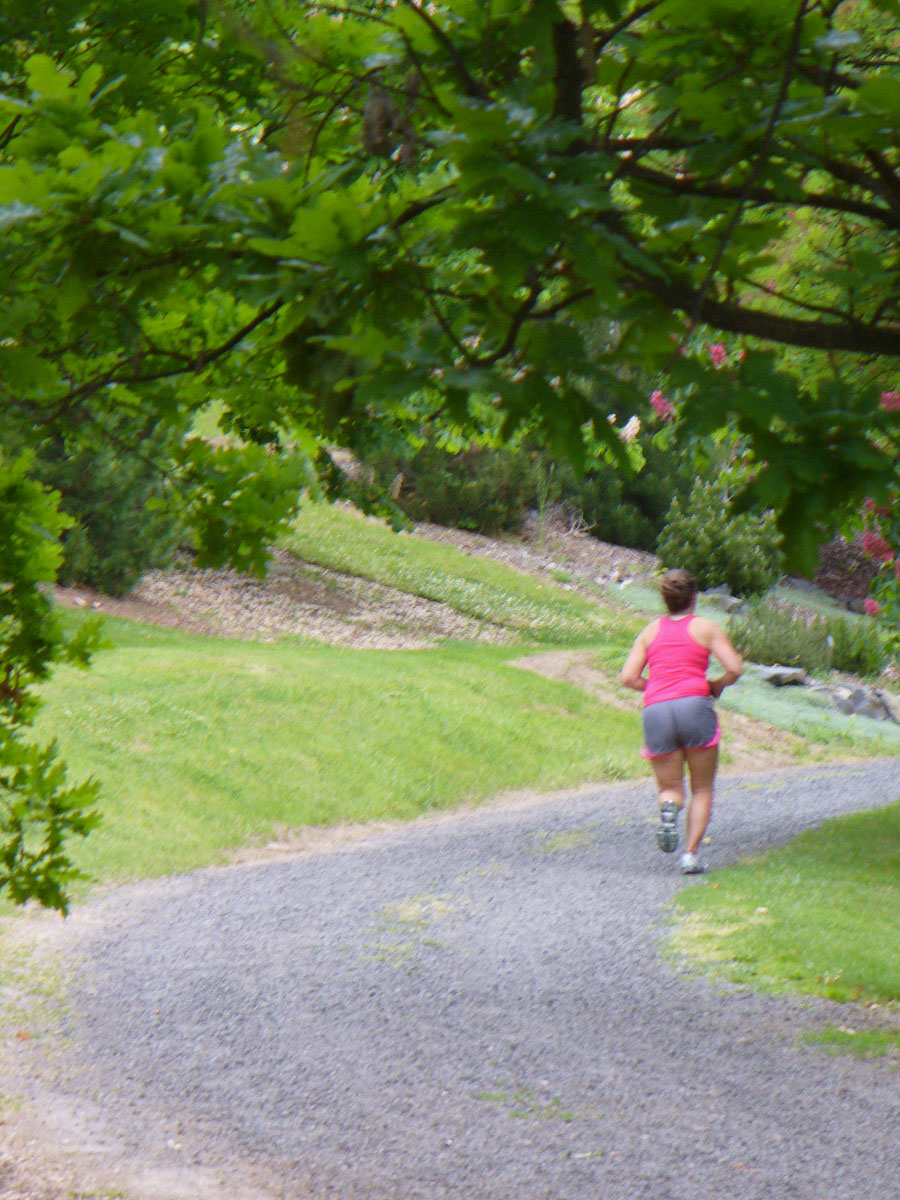Woman running in park by Susan Fluegel